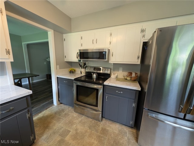 12274 Kile Rd, Chardon, OH 44024 - kitchen featuring appliances with stainless steel finishes, white cabinets, light stone counters, light stone finish floors, and gray cabinets