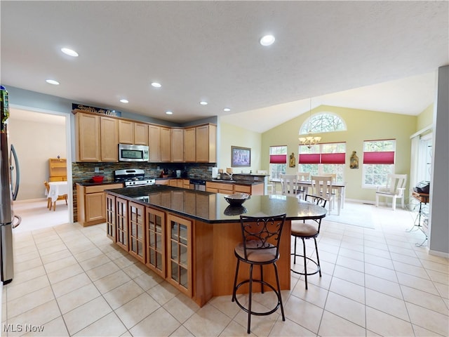 4171 Appleridge Ln, Richfield, OH 44286 - kitchen with stainless steel appliances, lofted ceiling, light tile patterned floors, glass insert cabinets, and decorative backsplash