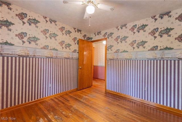 17444 Old State Rd, Middlefield, OH 44062 - unfurnished room with wallpapered walls, wood-type flooring, wainscoting, and a ceiling fan