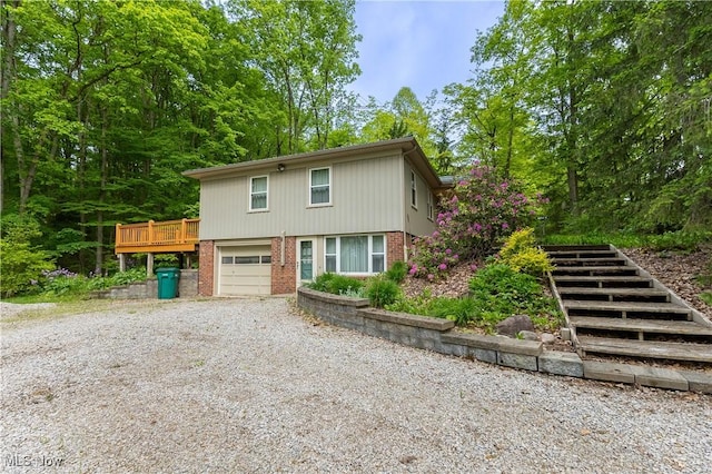 17444 Old State Rd, Middlefield, OH 44062 - view of front of house featuring brick siding, stairway, an attached garage, gravel driveway, and a wooden deck