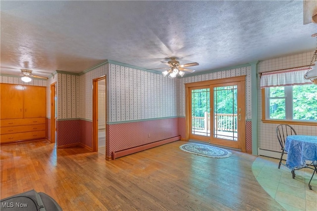 17444 Old State Rd, Middlefield, OH 44062 - unfurnished dining area featuring a ceiling fan, a baseboard heating unit, wallpapered walls, wood finished floors, and a textured ceiling