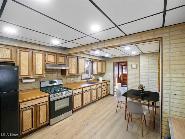 3000 Spitler Rd, Youngstown, OH 44514 - kitchen with freestanding refrigerator, stainless steel gas range oven, under cabinet range hood, a sink, and light countertops