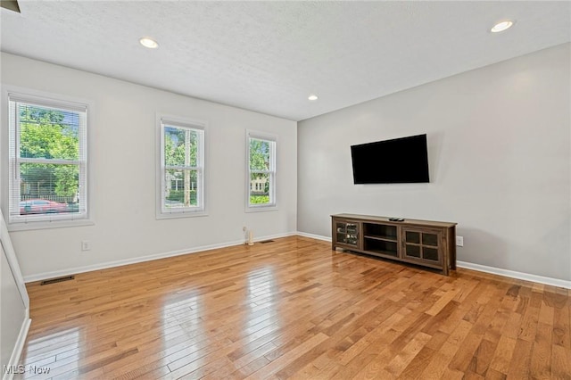 2450 Tremont Ave, Cleveland, OH 44113 - unfurnished living room featuring light wood finished floors, recessed lighting, and a textured ceiling