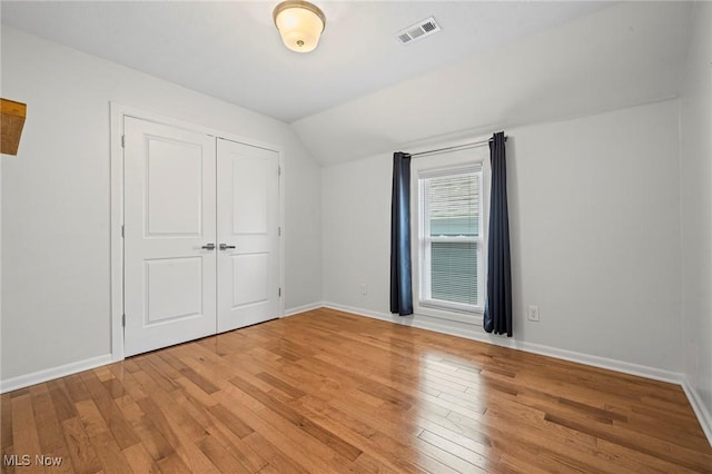 2450 Tremont Ave, Cleveland, OH 44113 - unfurnished bedroom with vaulted ceiling, light wood-type flooring, and a closet