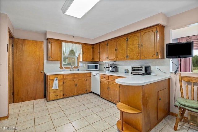 4002 Canterbury Ct, Lorain, OH 44053 - kitchen featuring stainless steel microwave, white dishwasher, and brown cabinetry