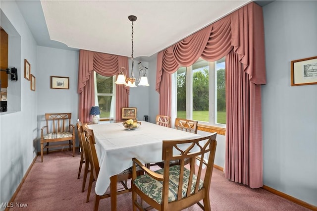 4002 Canterbury Ct, Lorain, OH 44053 - dining area featuring a chandelier, light carpet, and baseboards