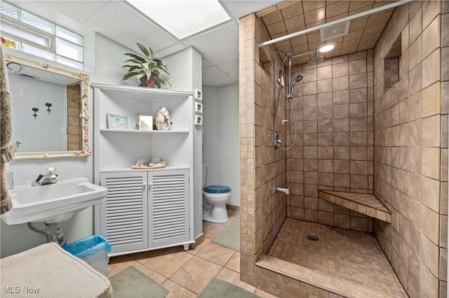 4002 Canterbury Ct, Lorain, OH 44053 - bathroom with toilet, a tile shower, tile patterned flooring, and a sink
