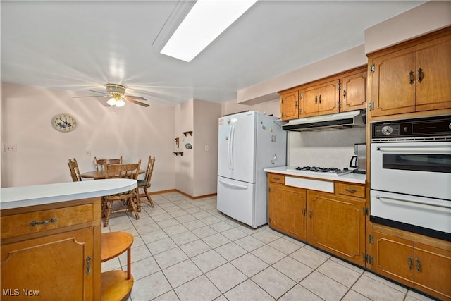 4002 Canterbury Ct, Lorain, OH 44053 - kitchen with white appliances, a warming drawer, under cabinet range hood, and brown cabinets