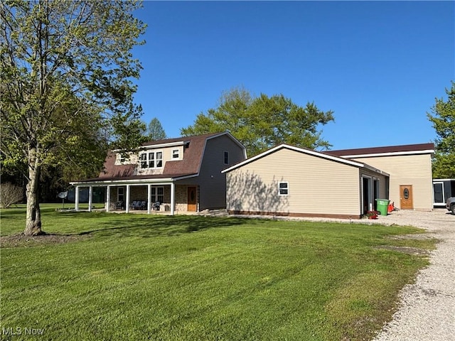 6516 Fee Rd, Rome, OH 44085 - back of house featuring a gambrel roof, a lawn, and gravel driveway