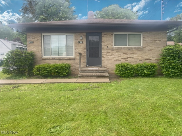 432-434 N Main St, Munroe Falls, OH 44262 - view of front facade with a front yard, brick siding, entry steps, and a chimney