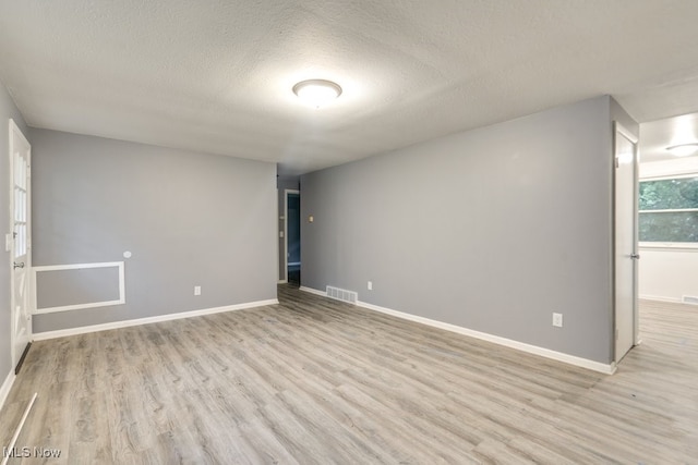 2318 3rd St SE, Canton, OH 44707 - spare room featuring light wood-type flooring, a textured ceiling, and baseboards