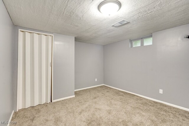 2318 3rd St SE, Canton, OH 44707 - below grade area featuring carpet flooring, baseboards, and a textured ceiling