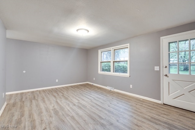 2318 3rd St SE, Canton, OH 44707 - entryway with light wood finished floors, plenty of natural light, baseboards, and a textured ceiling