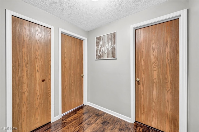 2300 Canterbury Cir, Akron, OH 44319 - unfurnished bedroom with dark wood-style flooring, multiple closets, baseboards, and a textured ceiling