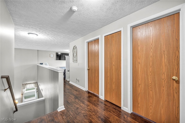 2300 Canterbury Cir, Akron, OH 44319 - hallway with an upstairs landing, dark wood-style flooring, a textured ceiling, and baseboards