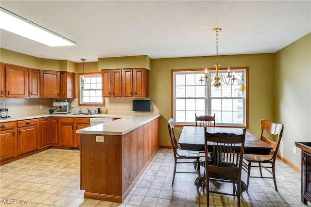 3690 Dornoch Dr, Wooster, OH 44691 - kitchen featuring a peninsula, brown cabinetry, a chandelier, and light countertops