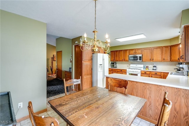3690 Dornoch Dr, Wooster, OH 44691 - kitchen featuring white appliances, a chandelier, light countertops, a sink, and brown cabinetry