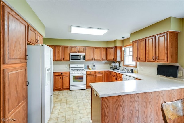 3690 Dornoch Dr, Wooster, OH 44691 - kitchen with white appliances, a peninsula, light countertops, a sink, and brown cabinets