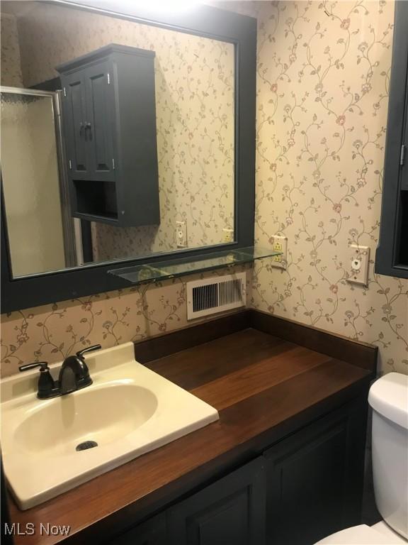 199 E 3rd St, Zoar, OH 44697 - full bath featuring wallpapered walls, toilet, a shower stall, and vanity