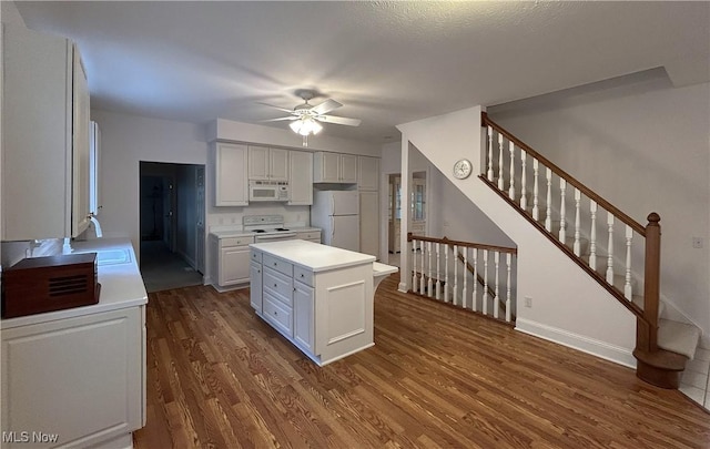 592 Charles Pl, Highland Heights, OH 44143 - kitchen featuring white appliances, dark wood finished floors, light countertops, ceiling fan, and a center island