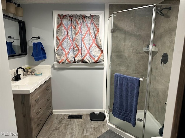 408 W Paradise St, Orrville, OH 44667 - full bathroom with vanity, wood finished floors, a shower stall, and baseboards