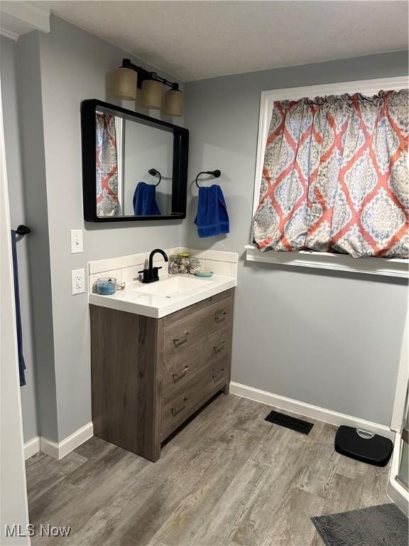 408 W Paradise St, Orrville, OH 44667 - bathroom featuring vanity, wood finished floors, and baseboards