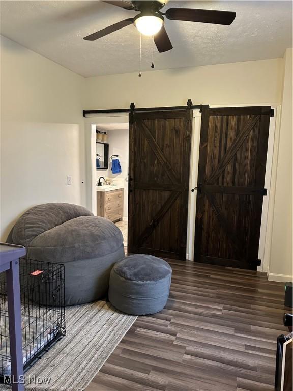 408 W Paradise St, Orrville, OH 44667 - living area with a ceiling fan, wood finished floors, a barn door, and a textured ceiling