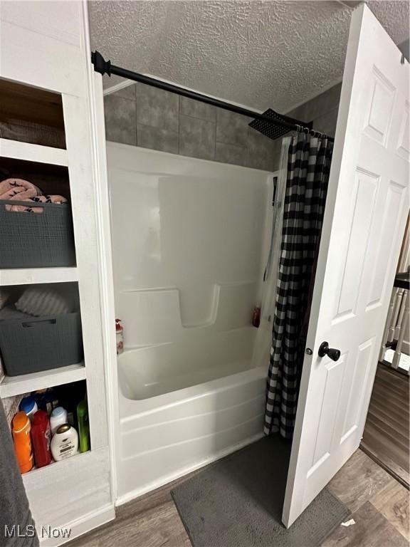 408 W Paradise St, Orrville, OH 44667 - full bath with shower / bath combo, wood finished floors, and a textured ceiling
