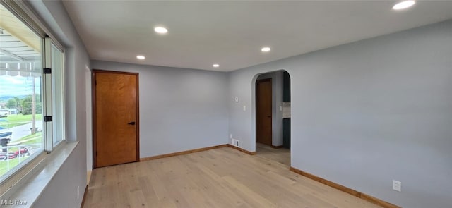 809 4th St, Brilliant, OH 43913 - empty room with arched walkways, light wood-style flooring, recessed lighting, and baseboards