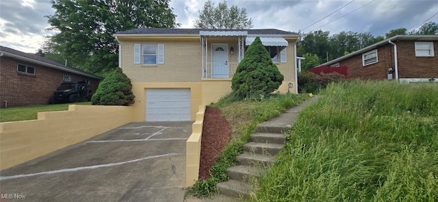 809 4th St, Brilliant, OH 43913 - bungalow with a garage, asphalt driveway, and brick siding