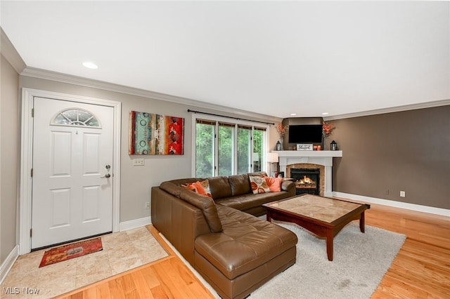 3576 Ellen Dr, Akron, OH 44312 - living area featuring a warm lit fireplace, ornamental molding, baseboards, light wood-type flooring, and recessed lighting