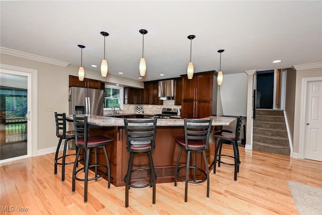 3576 Ellen Dr, Akron, OH 44312 - kitchen with stainless steel appliances, wall chimney exhaust hood, dark brown cabinets, light wood-style floors, and backsplash