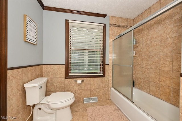 3576 Ellen Dr, Akron, OH 44312 - bathroom with toilet, tile walls, combined bath / shower with glass door, tile patterned flooring, and a textured ceiling