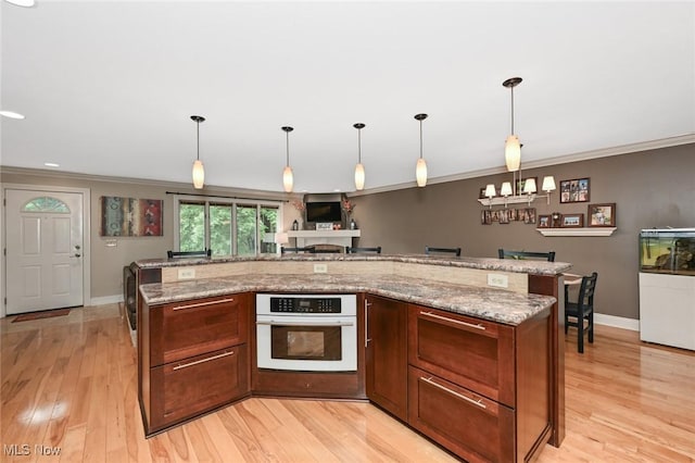 3576 Ellen Dr, Akron, OH 44312 - kitchen with white oven, crown molding, baseboards, light wood-style floors, and light stone countertops