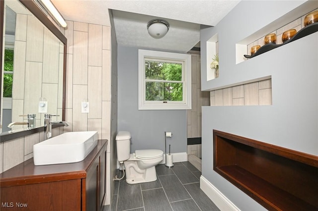 3576 Ellen Dr, Akron, OH 44312 - bathroom with toilet, vanity, baseboards, and tile patterned floors
