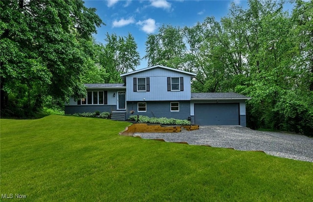 3576 Ellen Dr, Akron, OH 44312 - tri-level home with gravel driveway, an attached garage, and a front yard