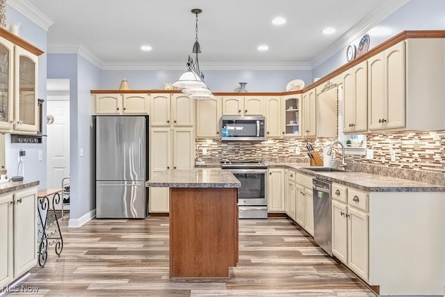 5215 Kapok Dr, Medina, OH 44256 - kitchen featuring stainless steel appliances, glass insert cabinets, a kitchen island, light wood-type flooring, and a sink