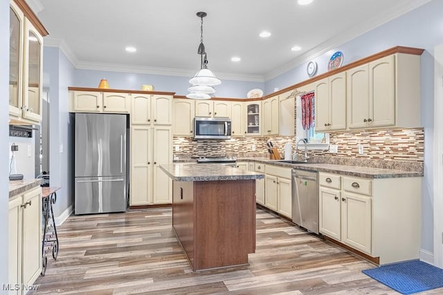 5215 Kapok Dr, Medina, OH 44256 - kitchen with stainless steel appliances, a sink, glass insert cabinets, light wood-style floors, and a center island