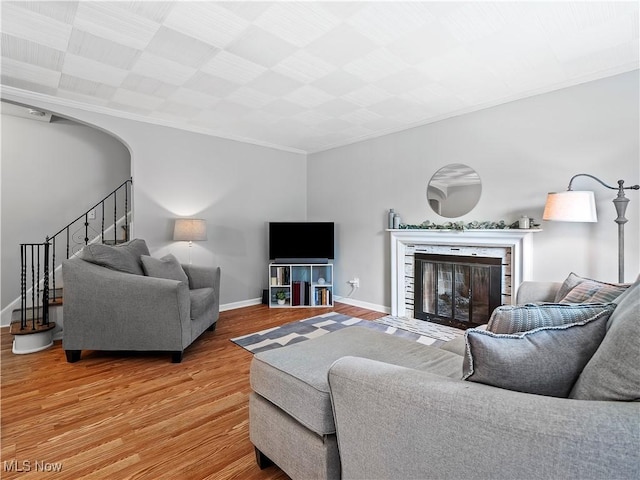 4482 Ranchview Ave, North Olmsted, OH 44070 - living area with light wood-type flooring, stairway, a fireplace with flush hearth, baseboards, and ornamental molding