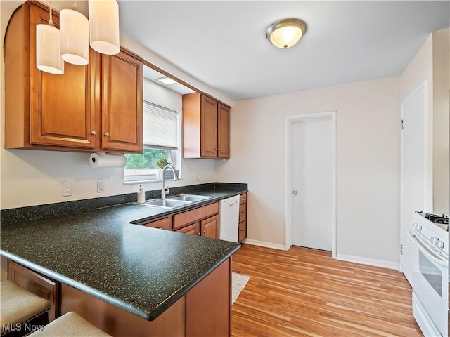 4482 Ranchview Ave, North Olmsted, OH 44070 - kitchen with a sink, white appliances, dark countertops, brown cabinetry, and light wood-style flooring
