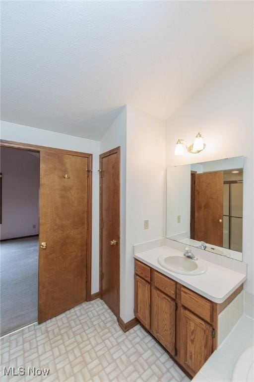 14250 Reserve Ln, Middleburg Heights, OH 44130 - bathroom with vaulted ceiling, vanity, and baseboards