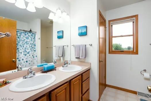 1339 Harmony Dr, Wadsworth, OH 44281 - full bathroom with double vanity, baseboards, and a shower with curtain