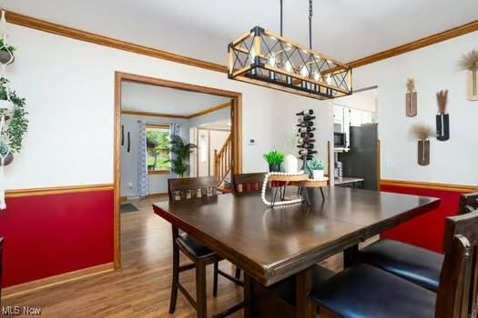 1339 Harmony Dr, Wadsworth, OH 44281 - dining area featuring crown molding, wood finished floors, a chandelier, and baseboards