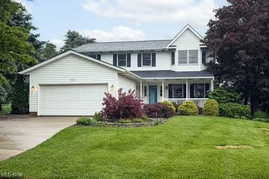 1339 Harmony Dr, Wadsworth, OH 44281 - traditional-style house featuring covered porch, an attached garage, concrete driveway, and a front yard