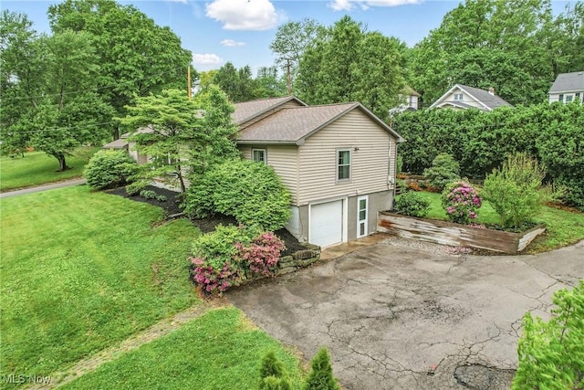 298 W Chestnut St, Lisbon, OH 44432 - view of side of home featuring asphalt driveway, an attached garage, a yard, and a shingled roof