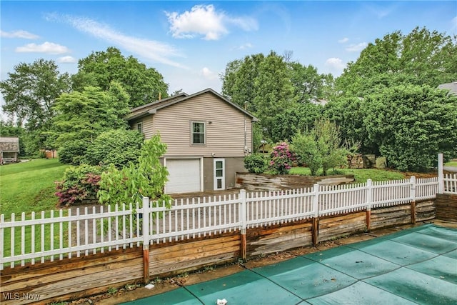 298 W Chestnut St, Lisbon, OH 44432 - rear view of house with an attached garage, view of wooded area, and driveway