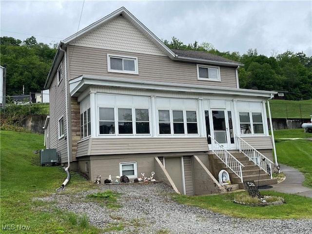 455 Smithfield St, Dillonvale, OH 43917 - view of front facade featuring a front lawn, central AC, and a sunroom