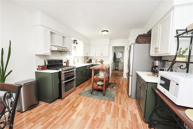 1087 Madrid Dr, Akron, OH 44313 - kitchen with appliances with stainless steel finishes, range hood, white cabinets, and light countertops