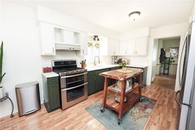 1087 Madrid Dr, Akron, OH 44313 - kitchen with stainless steel appliances, under cabinet range hood, white cabinets, light countertops, and light wood finished floors