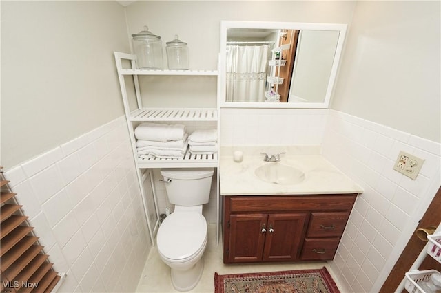 1087 Madrid Dr, Akron, OH 44313 - full bath with tile walls, toilet, vanity, and a wainscoted wall